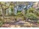 Backyard oasis with stone retaining walls, lush greenery, and mature trees, creating a serene and private outdoor space at 4090 Cherry Ridge Walk, Suwanee, GA 30024