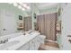 Well-lit bathroom with dual sinks, a shower-tub combo, and contemporary fixtures at 4090 Cherry Ridge Walk, Suwanee, GA 30024