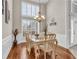 Bright dining room with hardwood floors, a decorative chandelier, and natural light from large windows with shutters at 4090 Cherry Ridge Walk, Suwanee, GA 30024