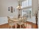 Formal dining room featuring wainscoting, hardwood floors, and elegant lighting, perfect for Gathering meals at 4090 Cherry Ridge Walk, Suwanee, GA 30024