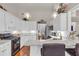 Modern kitchen featuring white cabinets, granite countertops, stainless steel appliances, and a breakfast bar with bar stools at 4090 Cherry Ridge Walk, Suwanee, GA 30024