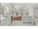 Bright kitchen with stainless steel appliances, island with chairs, fireplace, and white cabinets at 517 Toombs St, Palmetto, GA 30268