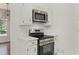 Modern kitchen with stainless steel microwave and oven surrounded by white cabinets at 517 Toombs St, Palmetto, GA 30268
