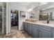 Bathroom featuring double sinks, gray cabinets, tile floor, with a view into the walk-in closet at 245 Piedmont Cir, Covington, GA 30016
