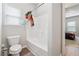 White bathroom featuring a toilet, bathtub with shower, and view into bedroom at 245 Piedmont Cir, Covington, GA 30016