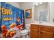 Colorful bathroom with a fun shower curtain and a wooden vanity at 245 Piedmont Cir, Covington, GA 30016