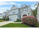 Two-story home with blue siding, stone accents, lush landscaping, and attached two-car garage at 3897 Lake Sanctuary Way, Atlanta, GA 30349