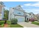 Two-story home with blue siding, stone accents, well-maintained lawn, and two-car garage at 3897 Lake Sanctuary Way, Atlanta, GA 30349