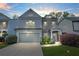 Charming two-story home with a two-car garage, stone accents, and manicured landscaping at twilight at 3897 Lake Sanctuary Way, Atlanta, GA 30349