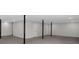Open basement with gray carpet, multiple black support poles, and a white door at 4453 Autumn Glo Ct Ct, Douglasville, GA 30135