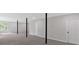 Large, open basement features gray carpeting, black support columns, and a window at 4453 Autumn Glo Ct Ct, Douglasville, GA 30135