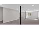 Unfinished basement space featuring gray carpet floors, black support poles, and a doorway at 4453 Autumn Glo Ct Ct, Douglasville, GA 30135