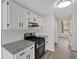 Modern kitchen featuring granite counters, stainless steel gas range, white backsplash, and cabinetry with black hardware at 4453 Autumn Glo Ct Ct, Douglasville, GA 30135