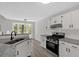 Well-lit kitchen with white cabinets, granite countertops, stainless steel appliances and an eat-in breakfast bar at 4453 Autumn Glo Ct Ct, Douglasville, GA 30135