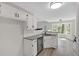 Bright kitchen features granite countertops, stainless steel dishwasher, and white cabinetry with black hardware at 4453 Autumn Glo Ct Ct, Douglasville, GA 30135