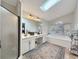 Bright bathroom with skylight, a double vanity, an oversized mirror, and a separate soaking tub at 7440 Banks Mill Rd, Douglasville, GA 30135