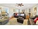 Inviting living room with hardwood floors, neutral paint, large sofa, and an adjacent view of the kitchen at 7440 Banks Mill Rd, Douglasville, GA 30135