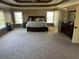 Spacious main bedroom with tray ceilings, carpeted floor, and natural light from large windows at 1210 Del Mar Club Dr, Dacula, GA 30019