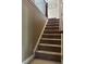Carpeted staircase with white risers and stained wood railing leads to upper level at 1210 Del Mar Club Dr, Dacula, GA 30019