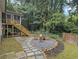 Backyard space with a firepit area surrounded by landscaping and stone pathways at 2810 Dunnington Cir, Chamblee, GA 30341