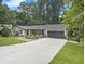 Daytime view of this charming home featuring a well-manicured lawn, and attached two-car garage at 2810 Dunnington Cir, Chamblee, GA 30341