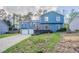 Charming blue two-story home with a driveway and a welcoming front deck, surrounded by lush greenery at 4809 Burlington Nw Ct, Acworth, GA 30102