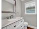 Powder room featuring white vanity, granite counters, window, and wood flooring at 111 Leathers Circle Nw, Atlanta, GA 30314