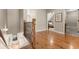 Bright hallway showcasing hardwood floors, iron railings, and access to bedrooms and bathrooms at 208 Greenhill Dr, Dallas, GA 30157