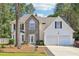Charming two-story home featuring a stone facade, white siding, a two-car garage, and a well-maintained front yard at 277 Edison Dr, Stockbridge, GA 30281