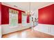 Formal dining room with red walls, chandelier, and natural light at 4461 Kentland Dr, Acworth, GA 30101