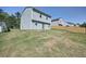 A two-story home with a grassy backyard, trees and a partial fence in the distance at 5675 Laurel Ridge Cir, Atlanta, GA 30344
