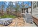 Stone patio, stairs to screened porch, fire pit, and view of landscaped backyard at 1190 Mosspointe Dr, Roswell, GA 30075