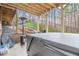 Back patio features a partially covered hot tub and outdoor seating with views of the wooded lot at 1190 Mosspointe Dr, Roswell, GA 30075