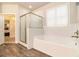 Modern bathroom featuring a soaking tub with shower, tile floors, and white cabinets at 1190 Mosspointe Dr, Roswell, GA 30075