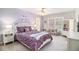 Stylish bedroom with purple accent wall, ceiling fan and built-in shelves at 1190 Mosspointe Dr, Roswell, GA 30075