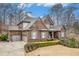 Beautiful brick home with a two-car garage, a well-kept lawn, and tasteful landscaping at 1190 Mosspointe Dr, Roswell, GA 30075