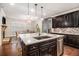 Bright kitchen with a center island, granite countertops, stainless steel appliances, and dark wood cabinets at 1190 Mosspointe Dr, Roswell, GA 30075