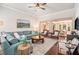 Bright living room with a blue sectional, hardwood floors, and seamless connection to the dining room at 1190 Mosspointe Dr, Roswell, GA 30075