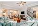 Bright living room with a blue sectional, wicker chairs, and hardwood floors at 1190 Mosspointe Dr, Roswell, GA 30075