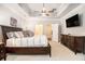 Main bedroom with tray ceilings, carpet, and dark wood furniture at 1190 Mosspointe Dr, Roswell, GA 30075