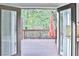 View from kitchen onto an outdoor deck and into a backyard with mature trees at 1147 Laurel Valley Ct, Buford, GA 30519