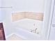 Large soaking tub with tile surround in a well-lit bathroom at 1147 Laurel Valley Ct, Buford, GA 30519