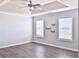 Spacious bedroom with tray ceiling, ceiling fan, and wood-look floors at 1147 Laurel Valley Ct, Buford, GA 30519