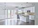 Well-lit kitchen featuring white cabinets, a granite island, and stainless steel appliances at 1147 Laurel Valley Ct, Buford, GA 30519
