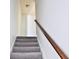 Carpeted staircase with a wooden handrail and a modern design at 1147 Laurel Valley Ct, Buford, GA 30519