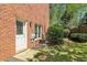 View of the backyard and the back of a red brick home, showing a door and window at 2130 Hollowbrooke Nw Way, Acworth, GA 30101