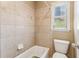 Cozy bathroom featuring a tiled shower with a bathtub, toilet, and window allowing natural light at 2130 Hollowbrooke Nw Way, Acworth, GA 30101