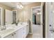 Bright bathroom featuring a double sink vanity, large mirror, and an open doorway to an adjacent room at 2130 Hollowbrooke Nw Way, Acworth, GA 30101