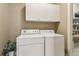 Convenient laundry area with white washer and dryer, white cabinets, and decorative plant at 2130 Hollowbrooke Nw Way, Acworth, GA 30101