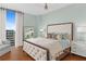 Inviting bedroom with a tufted headboard, hardwood floors, and large windows overlooking the city at 3300 Windy Ridge Se Pkwy # 1501, Atlanta, GA 30339